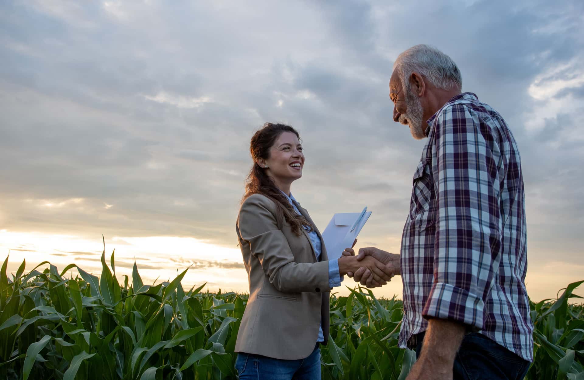Smiling farmer after closing land purchase deal supported by farm real estate loan